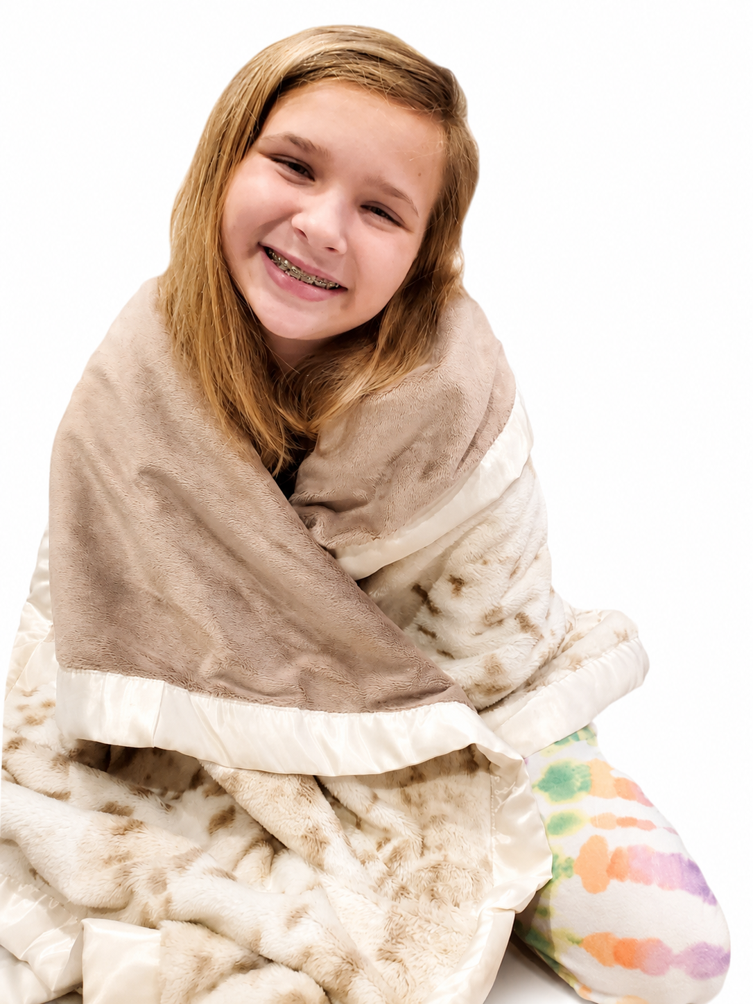 A child wrapped happily in a plush handmade blanket