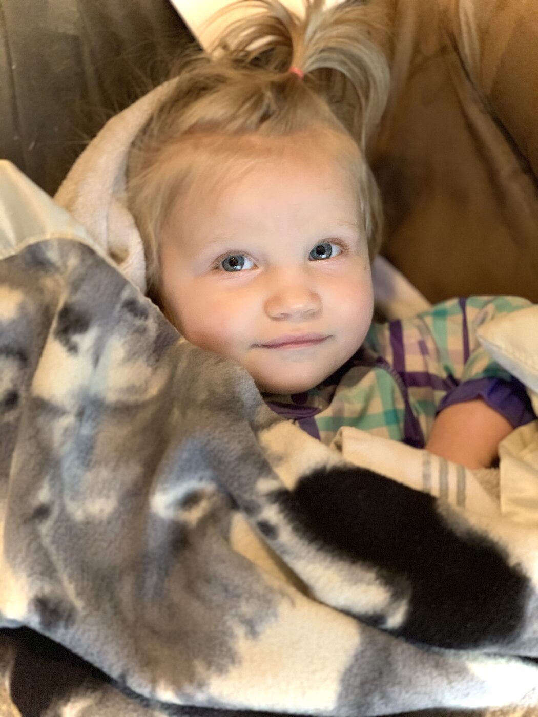 A toddler snuggled in a soft handmade blanket